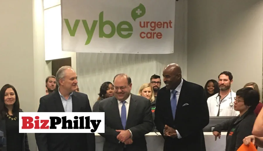 A wide view image of a group photo of vybe urgent care leadership and staff at a grand opening event for their new location at 1217 South Broad Street, South Philly.