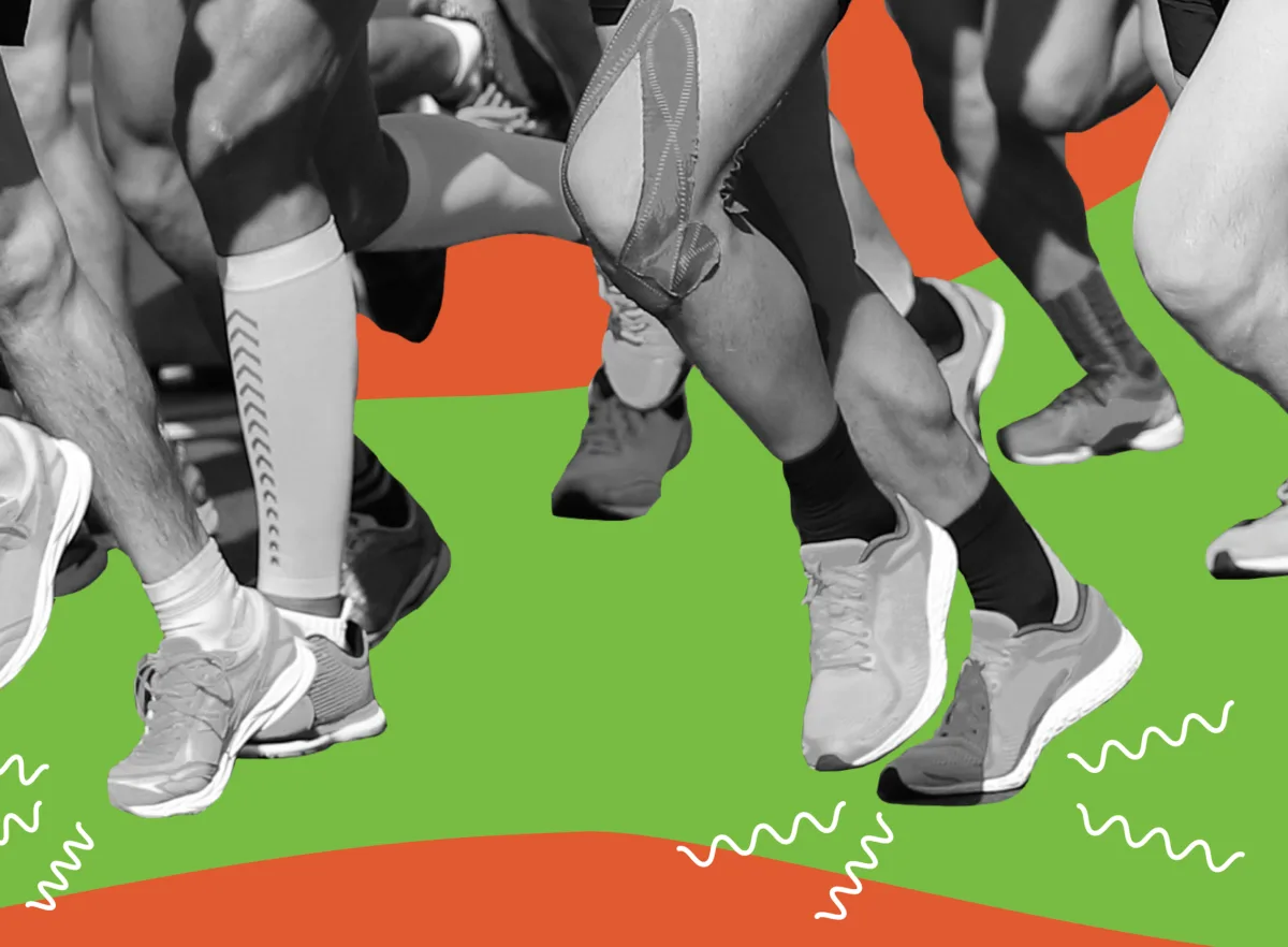 An image of black and white shot of a group of runners legs.