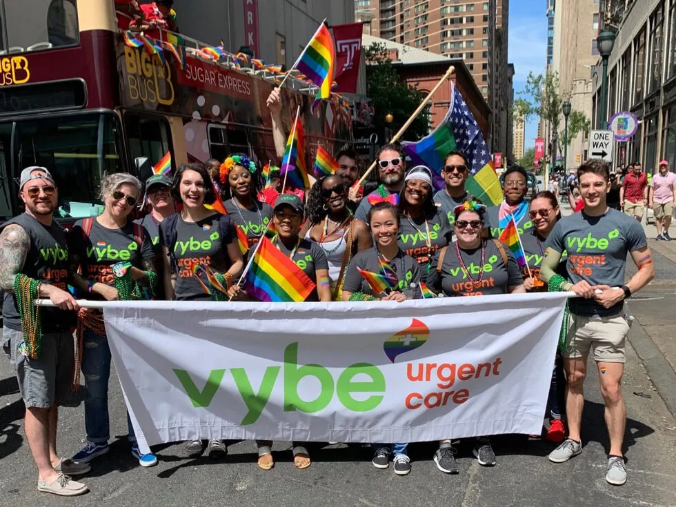 A group photo of vybe urgent care team members at a pride parade.