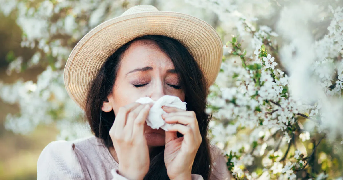 An image of a future vybe urgent care patient blowing her nose outdoors.