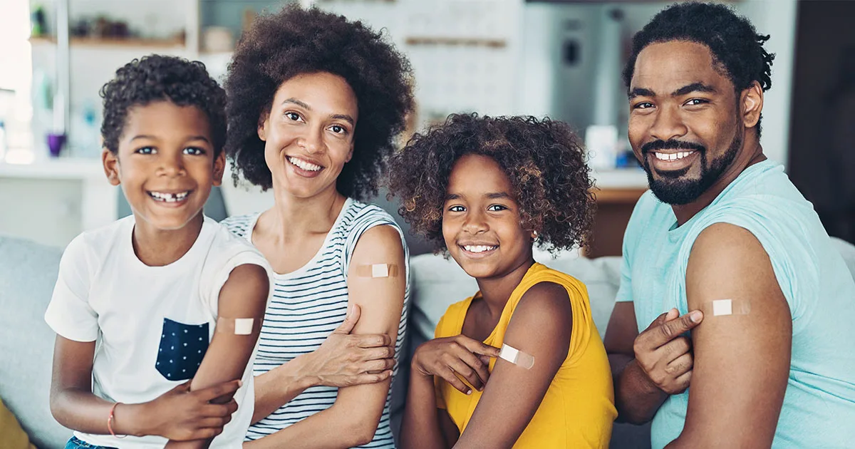 An enlarged image of a family smiling together after receiving shots at vybe urgent care.