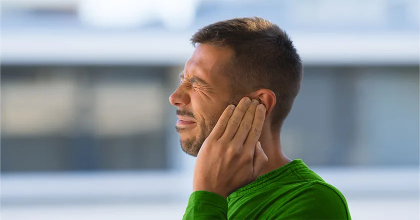 A future vybe urgent care male patient reminiscing in paint due to an earache.