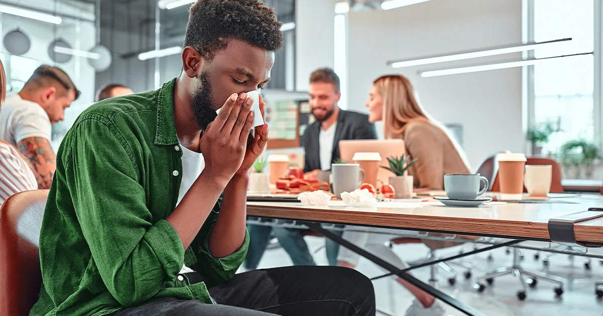 An enlarged image of a future vybe urgent care male patient blowing his nose due to having a sinus infection.