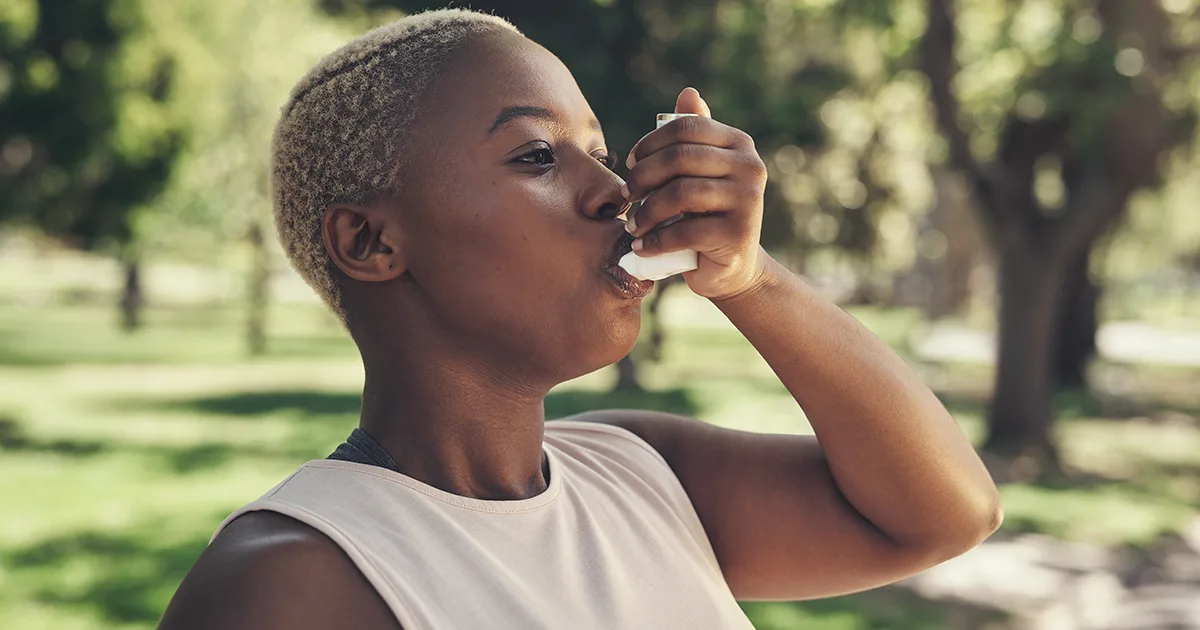 An image of a past vybe urgent care patient using an inhaler while at the park.