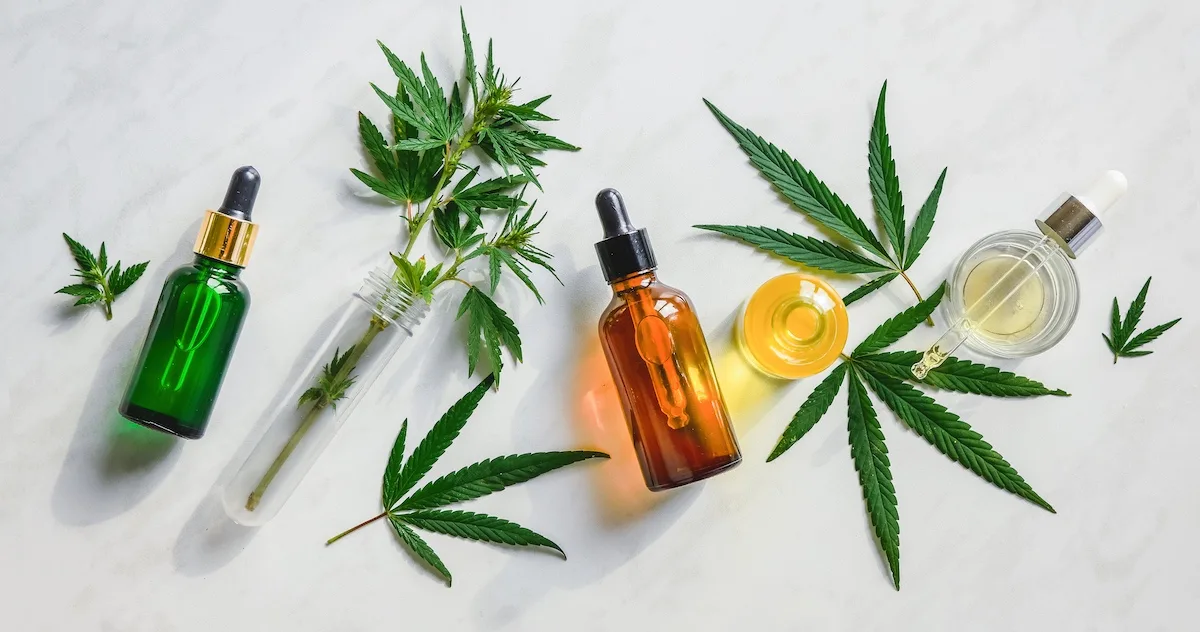 An enlarged image of an overhead shot of cannabis and bottles filled with cannabis oil.